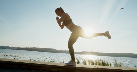 Engaging in a dynamic outdoor workout at sunrise near a serene body of water is truly invigorating