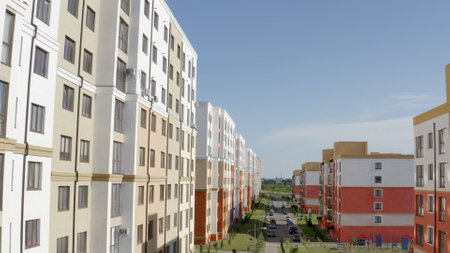 The modern apartment complex shines under a blue sky, showcasing contemporary living