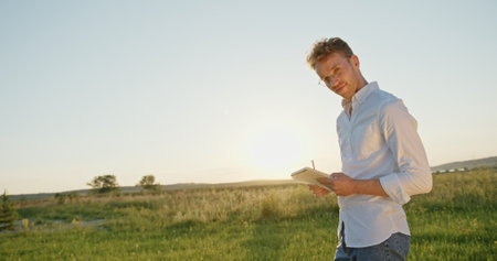 An individual engaged in writing outside during the enchanting golden hour light