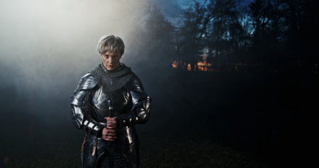 A Knight in Shining Armor Standing Tall Amid the Misty Enigmas of the Enchanted Forestの写真素材