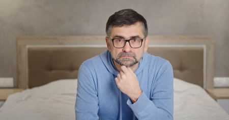 A Thoughtful Man in a Cozy and Warm Room Setting with a Relaxed and Calm Atmosphereの写真素材