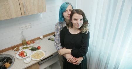 A couple happily cooking together in a modern kitchen, enjoying their culinary experience