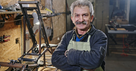 An artisan stands in a workshop filled with tools and equipment for crafting and design