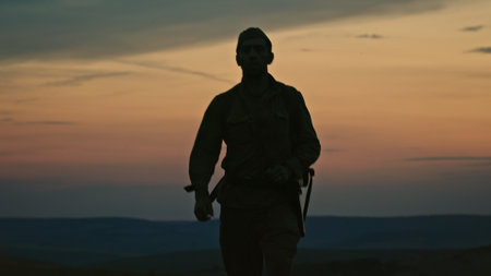 A lone soldier with a backpack from World War II returns home from the war walking through a summer...