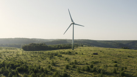 Ascending Drone View of a Wind Turbine on Green Fields