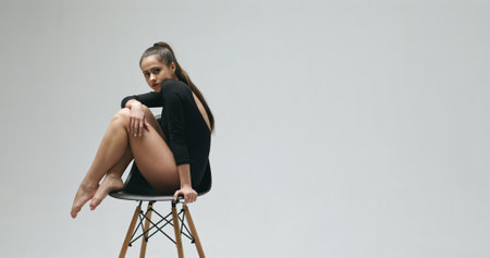 Woman in black bodysuit sitting on chair - slow motionの写真素材