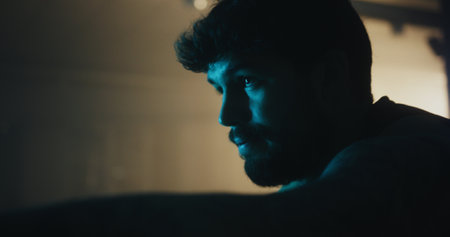 Intense Cardio Workout: Man Training on Cycling Machine in Moody Gymの写真素材