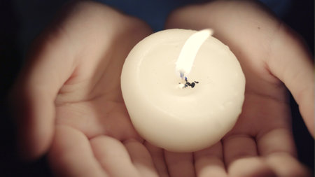 Portrait of the girl with a candle in hands. The spirituality face. Mood of sacrament and revelation