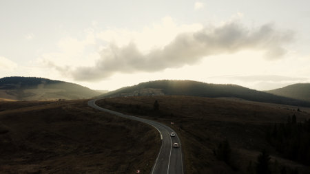 Mountain Road Winding Through Tranquil Hills at Dusk