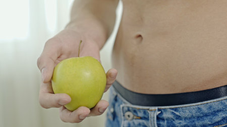Crop woman with green apple in hand