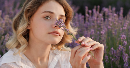 Joyful Moment: Young Woman with Lavender Flowers at Duskの写真素材
