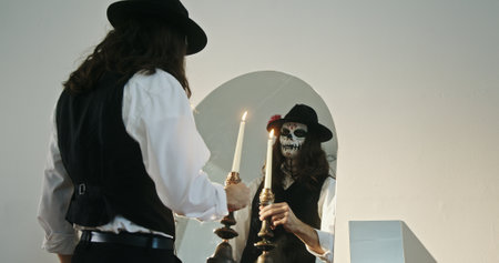 A Mysterious Figure Dressed in a Hat and Mask is Holding Flickering Candles for Ambience