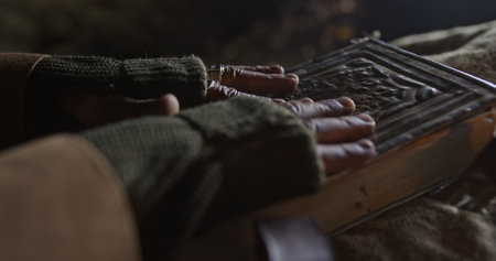 An Atmospheric Scene Featuring Hands Casually Resting on an Enigmatic and Mystical Book
