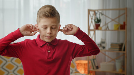 A child covers their ears in the living room, displaying discomfort and frustration from noise