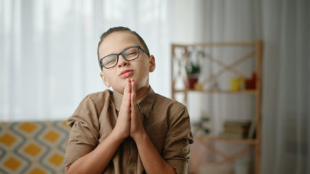 A Thoughtful Young Boy Wearing Glasses in a Cozy Indoor Setting Surrounded by Warmth and Emotions