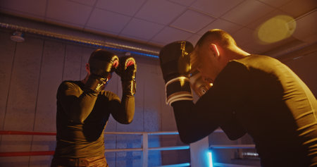 Slow Motion Sparring: Two Boxers Exchange Blows in a Color-Lit Ring