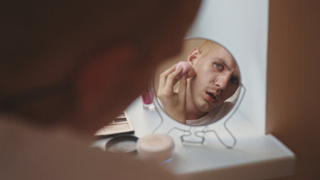 Person Applying Makeup in Front of a Lit Mirror