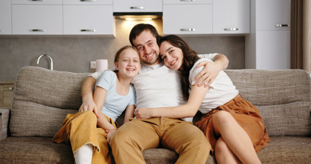 A Beautiful Family Embrace Happening on the Couch in a Modern Living Room Design