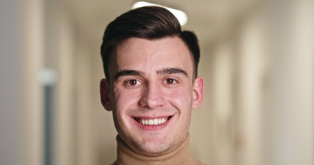 Confident Young Man with a Bright Smile in Clinic Hallway