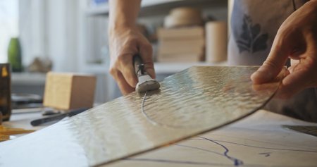 Artist Cutting Colored Glass for Floral Mirror Design in Workshop