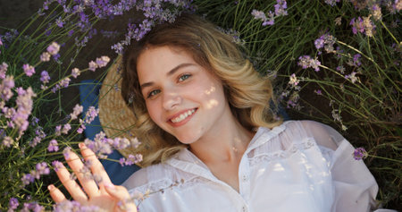 Blissful Young Woman Lying in Lavender Field, Gazing Up with a Joyful Smileの写真素材
