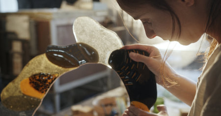 Artist Crafting a Floral-Shaped Mirror from Colored Glass in Studio