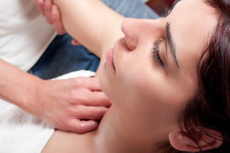 osteopathy procedure in a shoulder of a young womanの写真素材