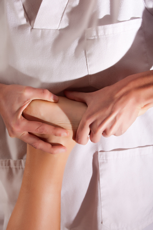 osteopathy procedure in a foot of a young womanの写真素材