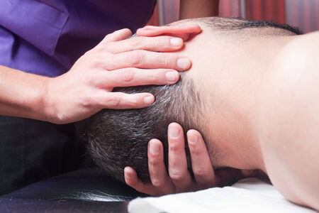 osteopathi technique is being used to treat a mans neckの写真素材