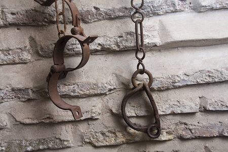 slave handcuffs holding from a wallの写真素材