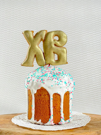Easter cake on a lace napkin on a wooden board on a white table on a white background. Cake with...