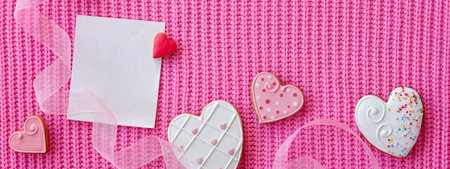 Greeting card mockup, white blank card and ribbon and heart shaped ginger cookies on pink background. Valentines dayの写真素材
