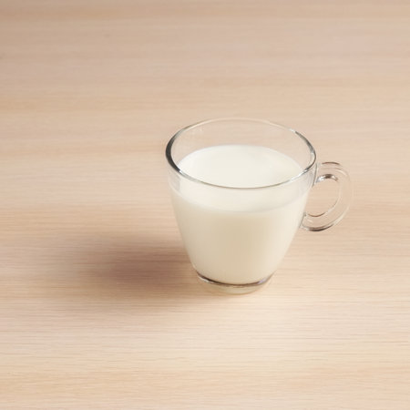 Transparent cup with milk on a wooden table. Delicious Drink in a glassの写真素材
