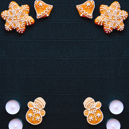 Christmas background. Gingerbread and fir branches on a background of dark craft paper. View from...