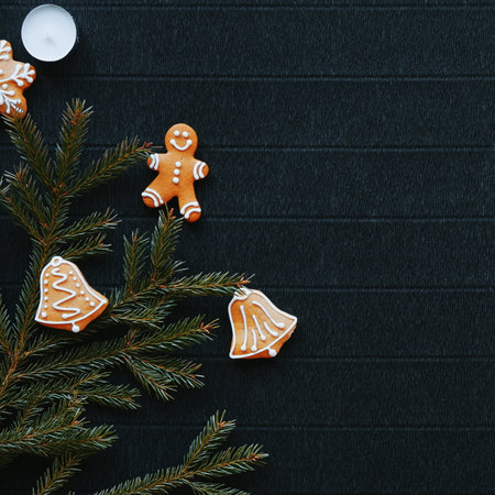 Top view of gingerbread and fir branches on a dark craft paper background, creating a New Years themed ambianceの写真素材