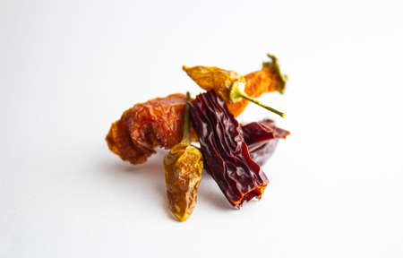 Collection of fresh red toned vegetables and fruits raw produce on white rustic background, peppers capsicum chilli strawberry raspberry pomegranate tomato paprika azuki beans plumの写真素材