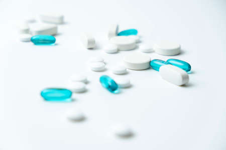 white and blue pills isolated on white backgroundの写真素材