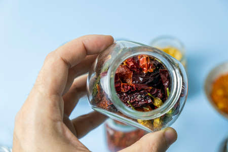 Close-up, a man holding a jar with dry useful herb for brewing. Herbs for the treatment of folk...