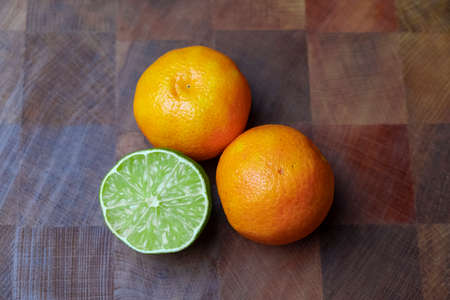 tangerines and lime on wooden table
