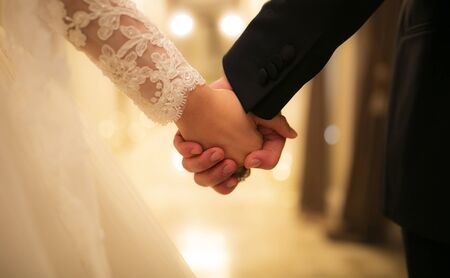 Bride and groom holding handsの写真素材