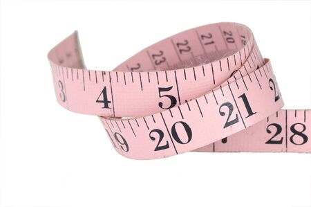 Pink measuring tape isolated over whiteの写真素材