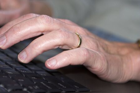 One hand typing on a laptop computerの写真素材