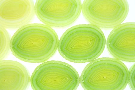 Leek slices background. Sliced vegetable abstract texture.