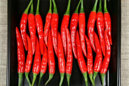 Red hot chilli peppers on the black background.