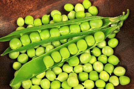 Fresh green peas in a wooden bowl.の写真素材