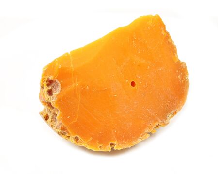Piece off cheese mimolette on white background.