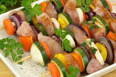 Grill skewer shashliks preparation - delicious meat cuisine with zucchini, onions, carrots and peppersの写真素材