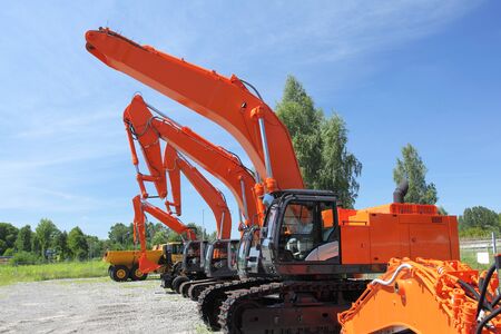 New, shiny and modern orange excavator machines. Construction industry machinery.