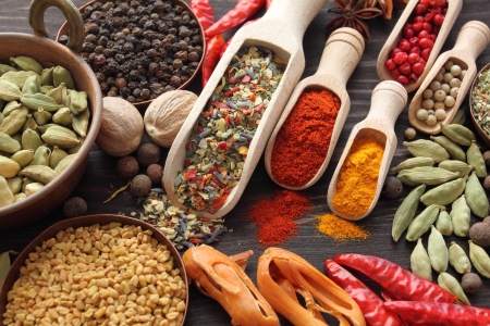 Colorful spices on wooden spoons and copper bowl - beautiful kitchen image.の写真素材