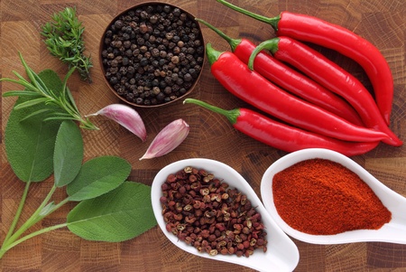 Peppers, spices and herbs on a wooden kitchen board 